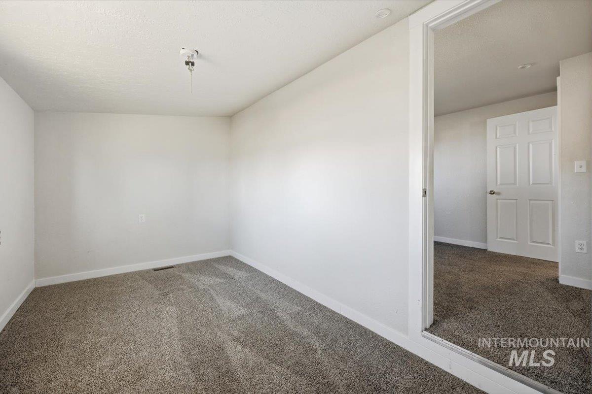 956 Southeast Hamilton Road Mountain Home, ID 83647 - Photo 30 of 34 Neutral-toned room featuring light gray walls and plush gray carpet