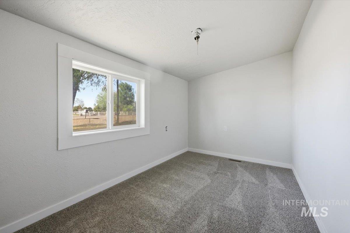 956 Southeast Hamilton Road Mountain Home, ID 83647 - Photo 31 of 34 White-painted interior room with gray patterned carpet