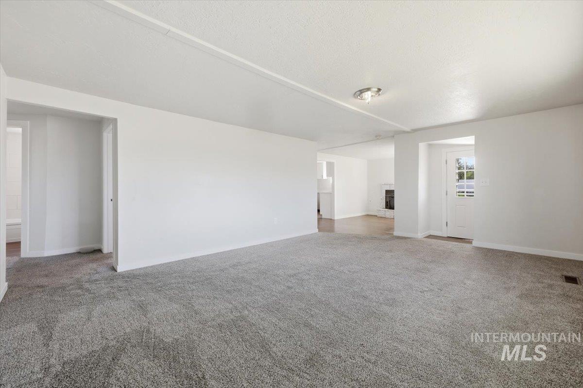 956 Southeast Hamilton Road Mountain Home, ID 83647 - Photo 9 of 34 Spacious living area featuring neutral-toned carpeting and white walls