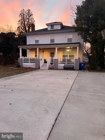 a view of a house with large space and a car parked in front of it