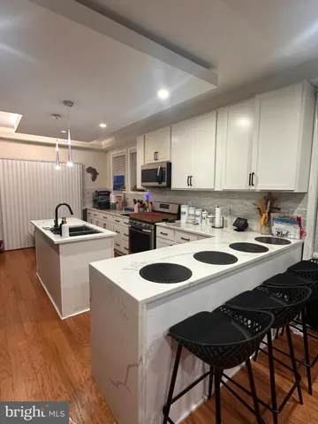 a kitchen with a sink a kitchen island and stainless steel appliances