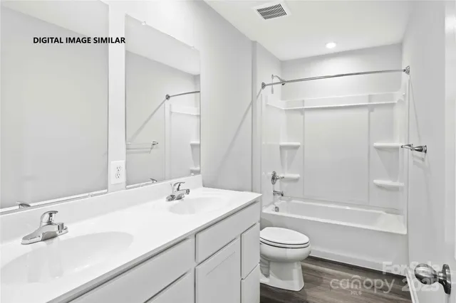 a bathroom with a granite countertop sink a toilet and shower