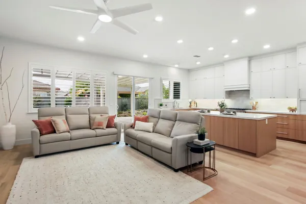 a large kitchen with stainless steel appliances a sink a counter top space and cabinets