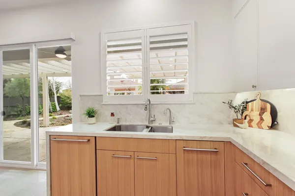 a view of kitchen with stainless steel appliances kitchen island refrigerator stove and chair