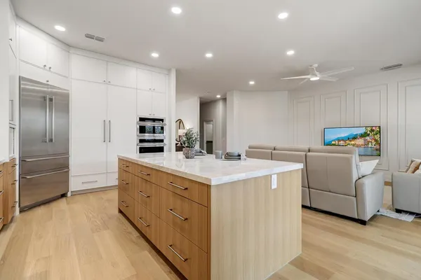 a spacious bedroom with a bed and a flat screen tv