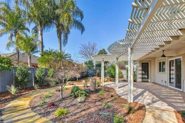 a view of a patio with couches table and chairs and potted plants