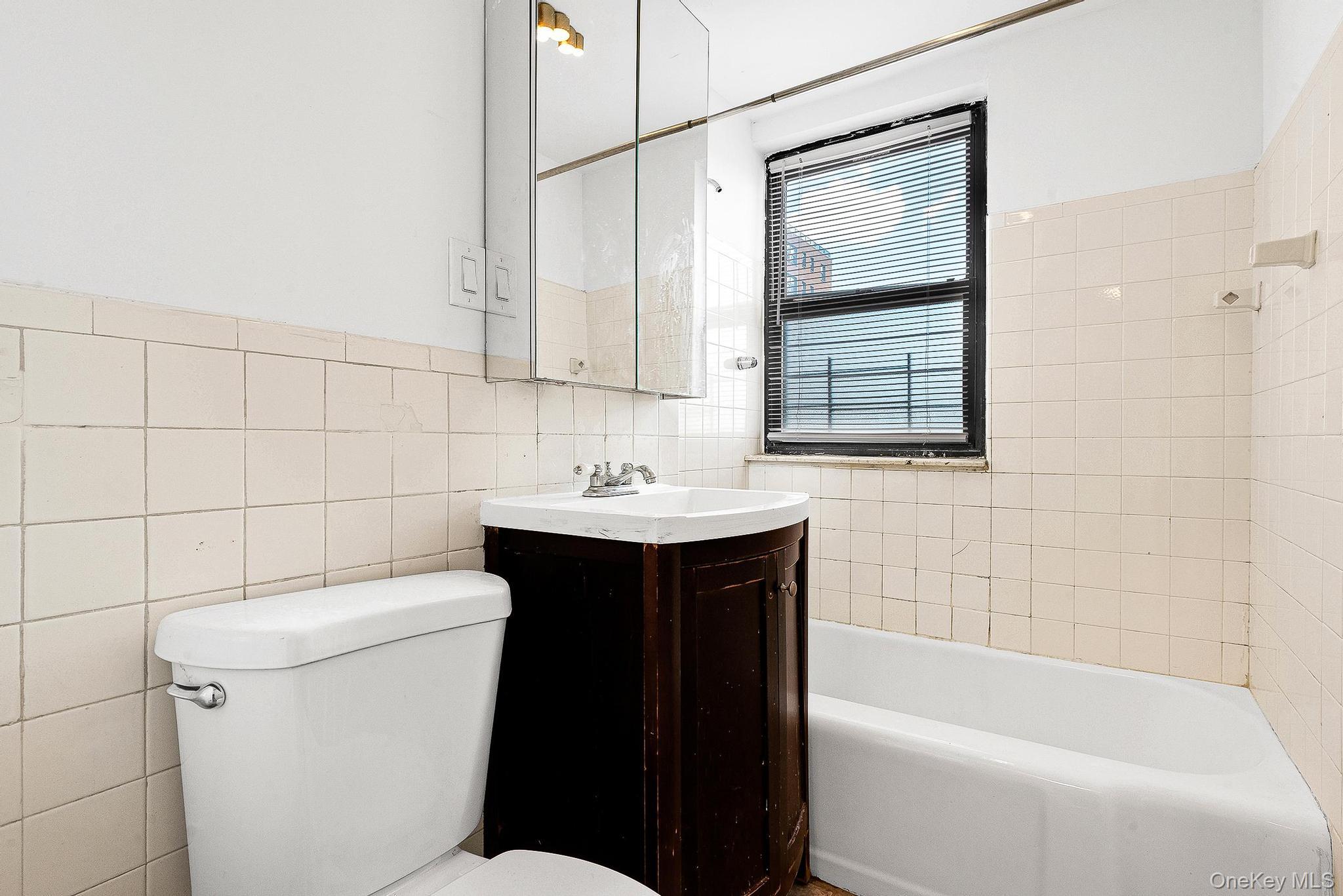 99-32 66th Road, Unit 5B Queens, NY 11374 - Photo 12 of 27 Full bathroom with vanity, tile walls, and tub / shower combination