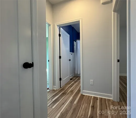 a view of a hallway with wooden floor and closet