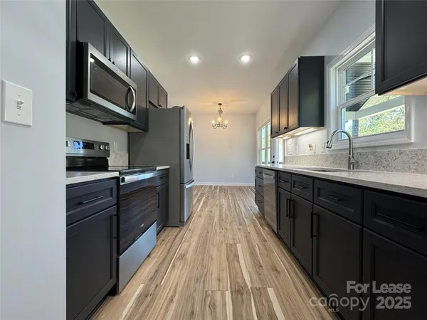 a kitchen with stainless steel appliances granite countertop a sink stove and refrigerator
