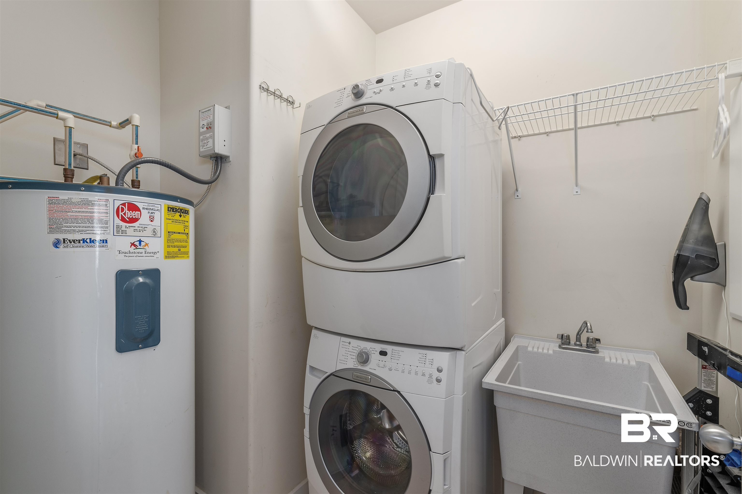 28107 Perdido Beach Boulevard, Unit DPH06 Orange Beach, AL 36561 - Photo 20 of 70 Clothes washing area with sink, stacked washer and dryer, and water heater