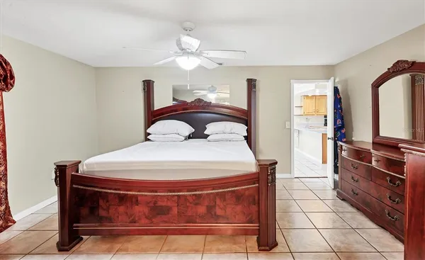 a bedroom with a large bed and a ceiling fan