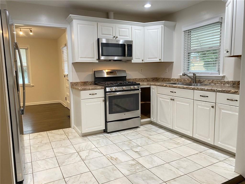 330 Community Drive Mableton, GA 30126 - Photo 11 of 47 a kitchen with stainless steel appliances granite countertop a stove a sink and a refrigerator