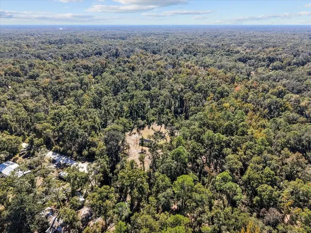 an aerial view of house with yard and mountain view in back