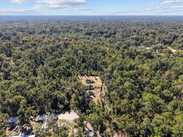 an aerial view of house with yard and mountain view in back