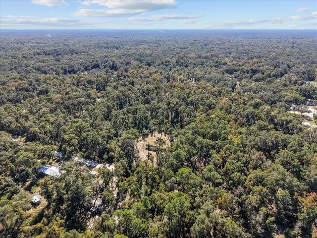 an aerial view of house with yard and mountain view in back