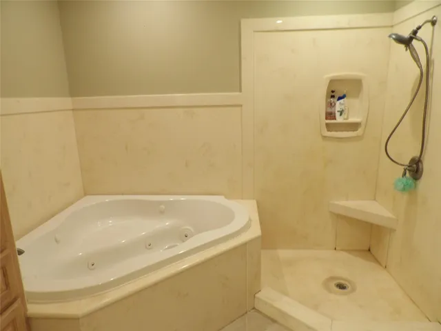 a bathroom with a tub sink and mirror