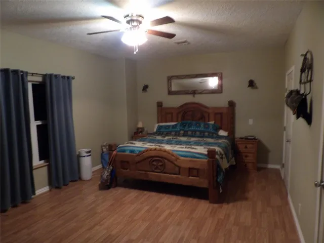 a bedroom with a bed and a flat tv screen on dresser