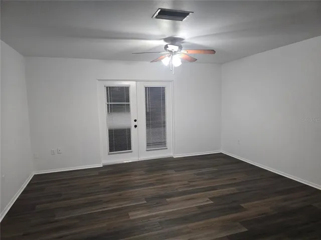 a view of an empty room with wooden floor