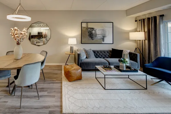 a living room with furniture a mirror and wall paintings
