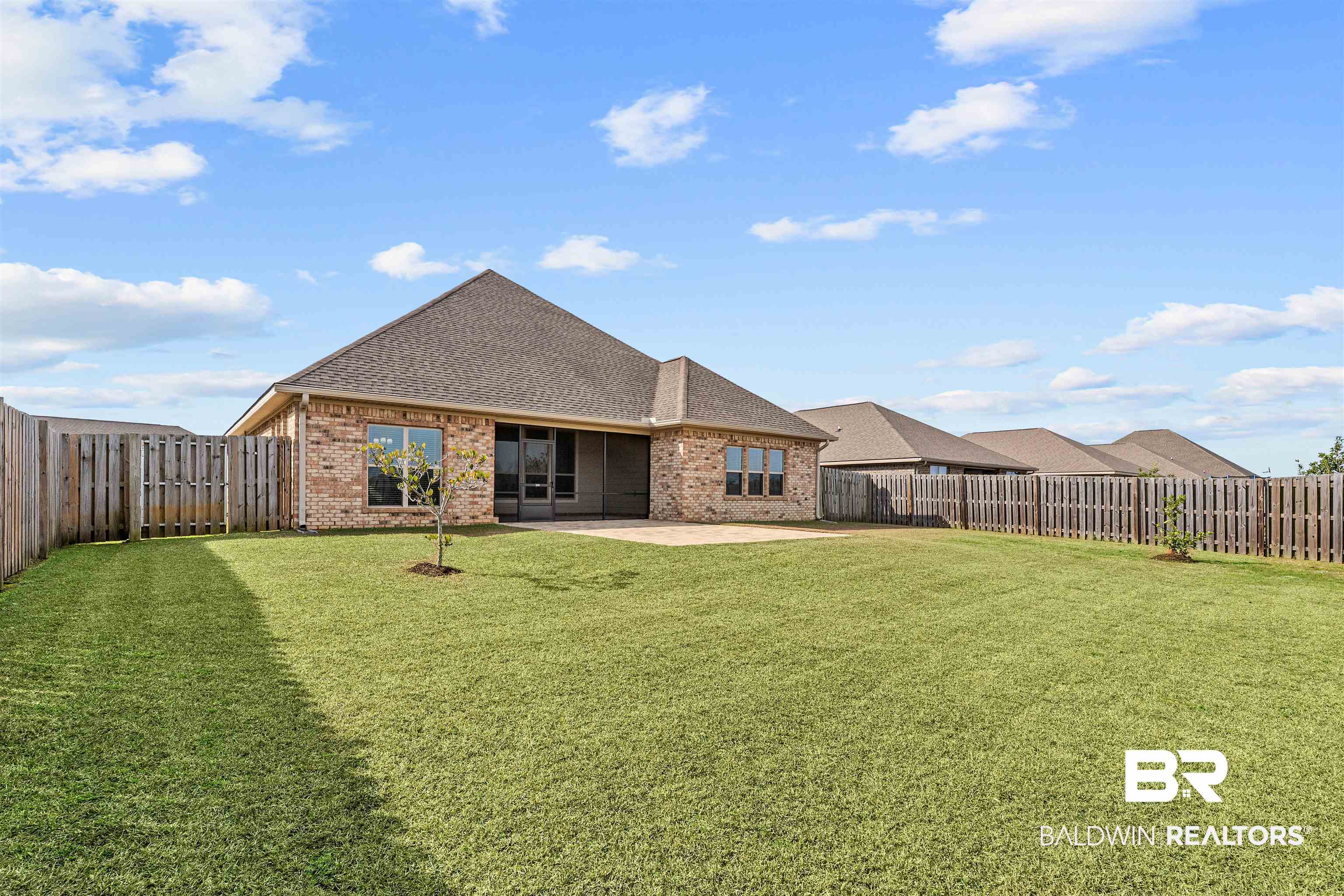 24838 Slater Mill Road Daphne, AL 36526 - Photo 45 of 46 Back of property with a shingled roof, brick siding, a patio, and a fenced backyard