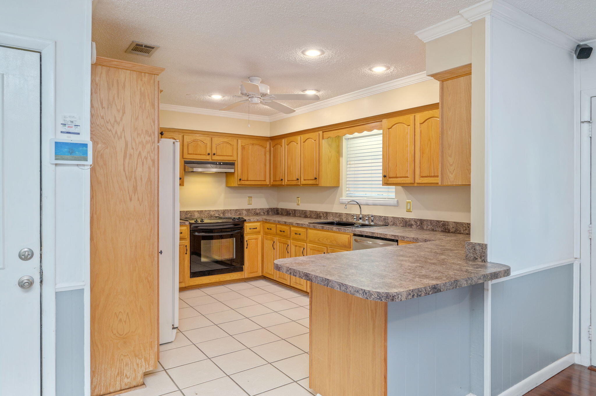 5770 Wildwood Road Crestview, FL 32536 - Photo 11 of 39 a kitchen with a refrigerator a sink and a stove top oven