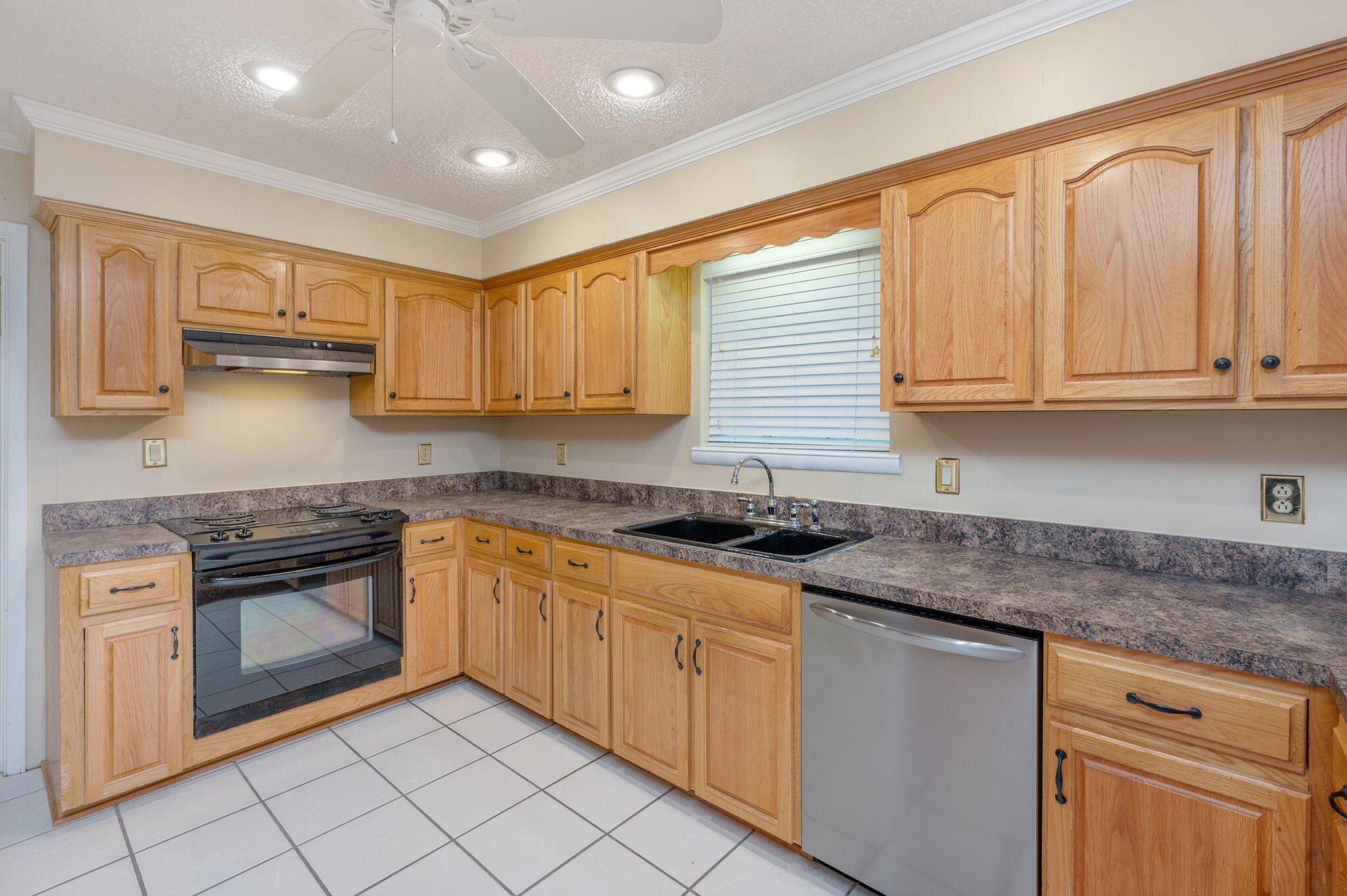 5770 Wildwood Road Crestview, FL 32536 - Photo 12 of 39 a kitchen with stainless steel appliances granite countertop a stove a sink and a microwave