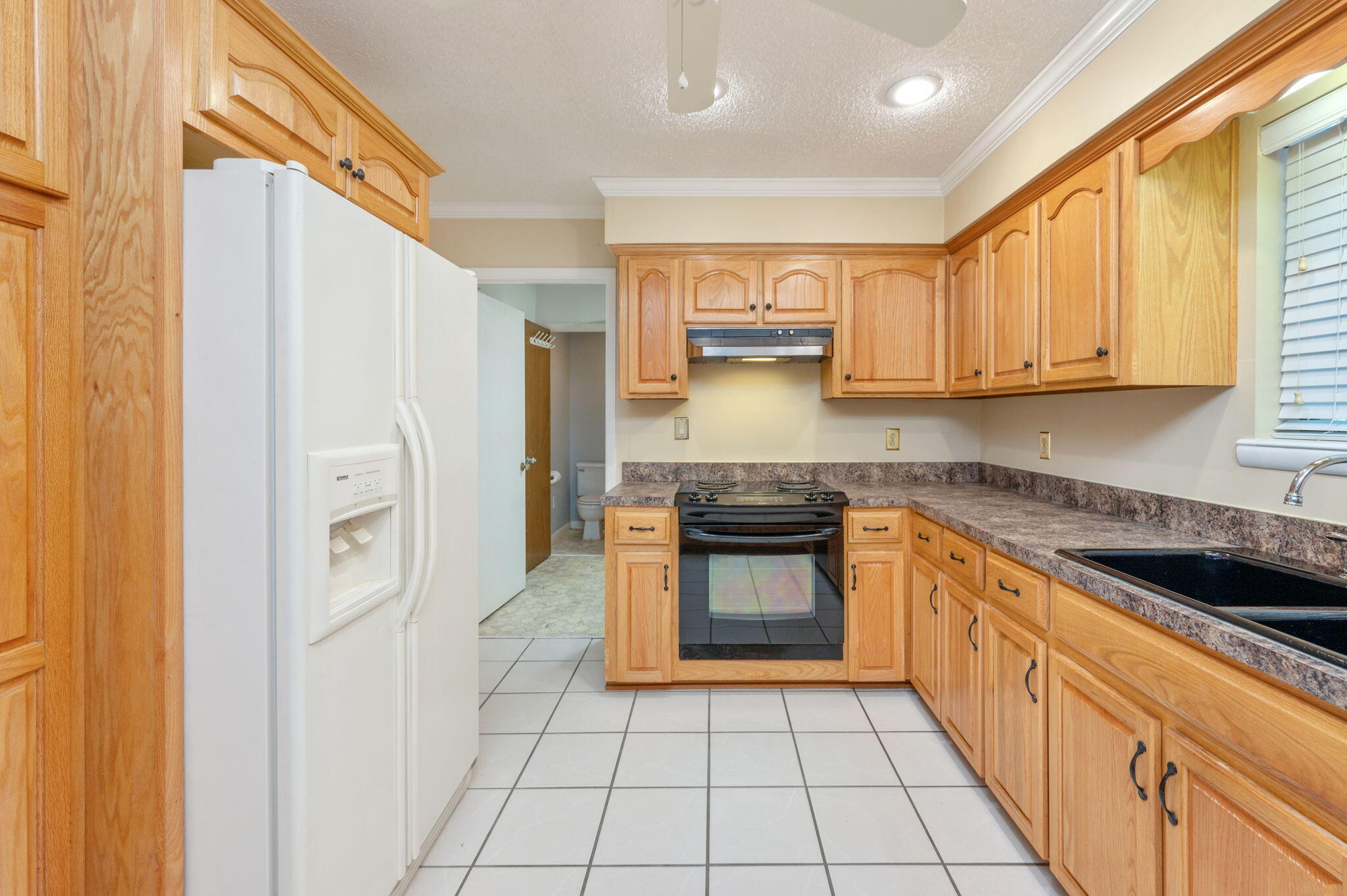 5770 Wildwood Road Crestview, FL 32536 - Photo 13 of 39 a kitchen with stainless steel appliances granite countertop a stove a sink and a refrigerator