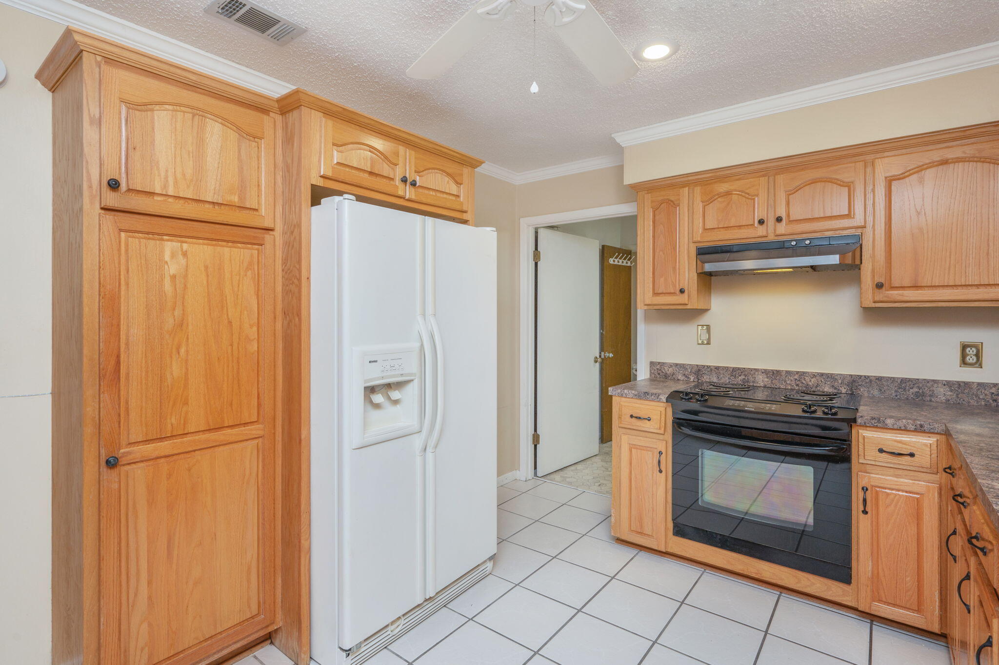 5770 Wildwood Road Crestview, FL 32536 - Photo 16 of 39 a kitchen with granite countertop a refrigerator stove and cabinets