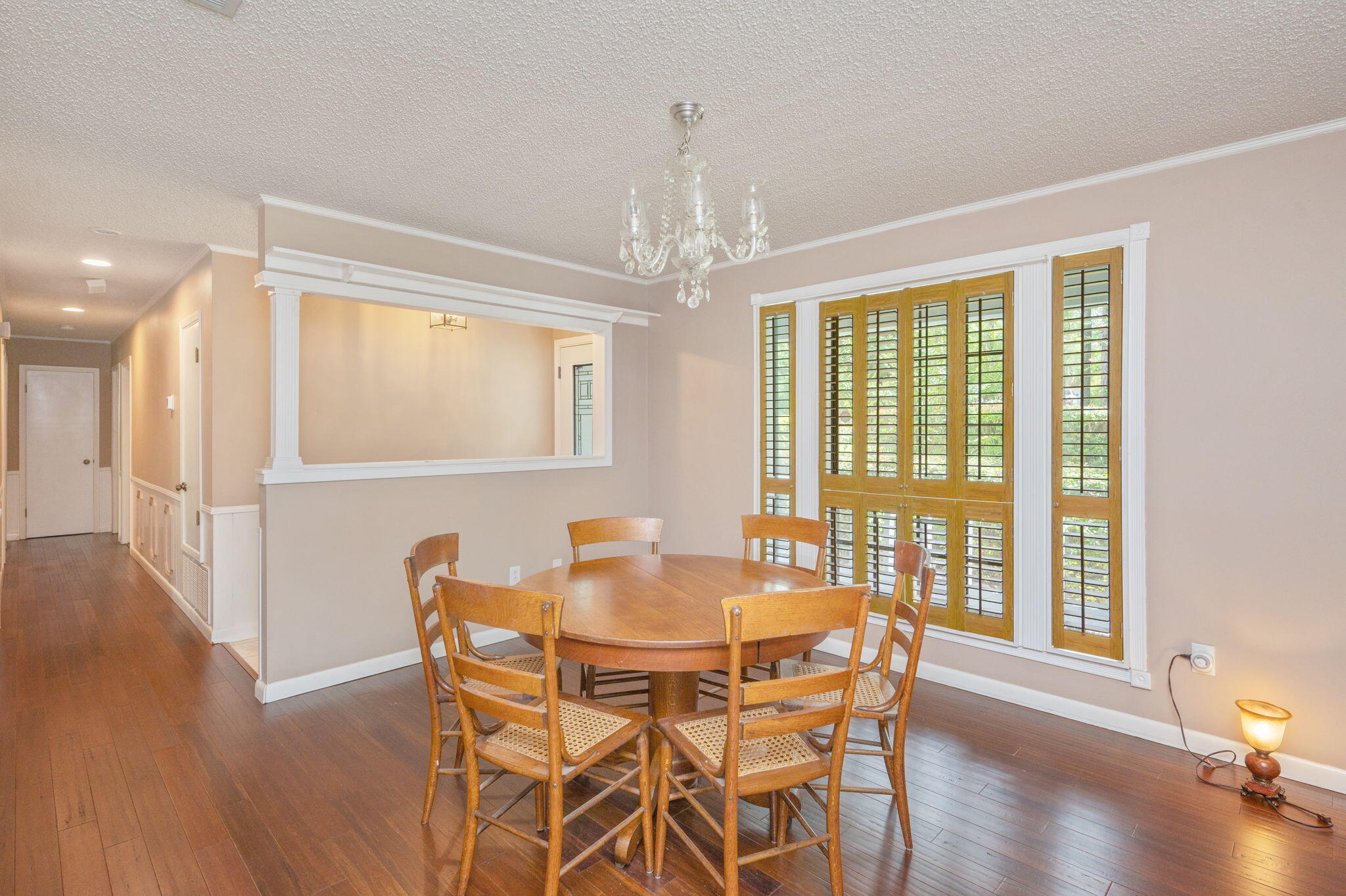 5770 Wildwood Road Crestview, FL 32536 - Photo 17 of 39 a dining room with wooden floor a chandelier a glass table and chairs