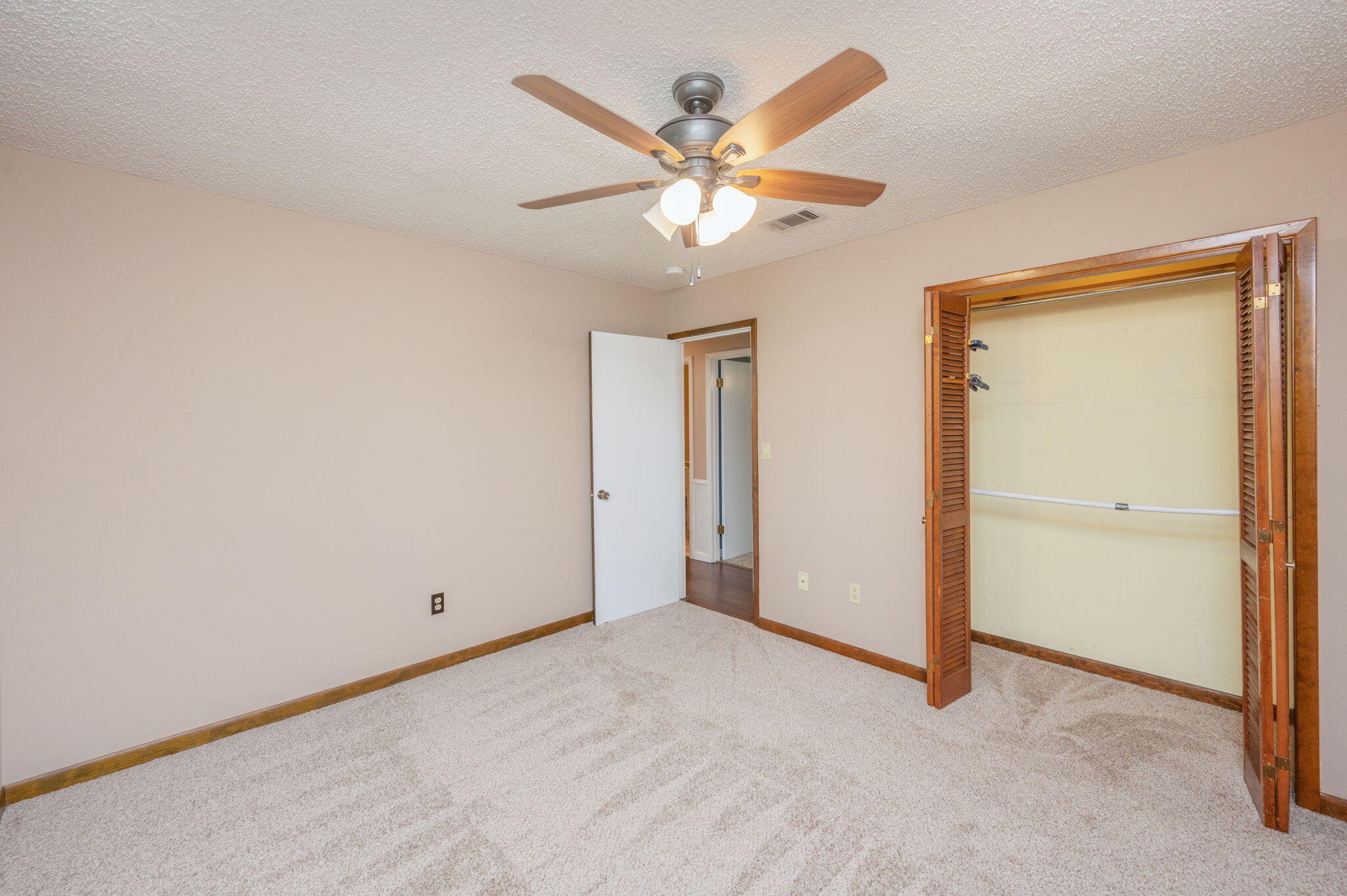 5770 Wildwood Road Crestview, FL 32536 - Photo 26 of 39 an empty room with closet and a chandelier fan