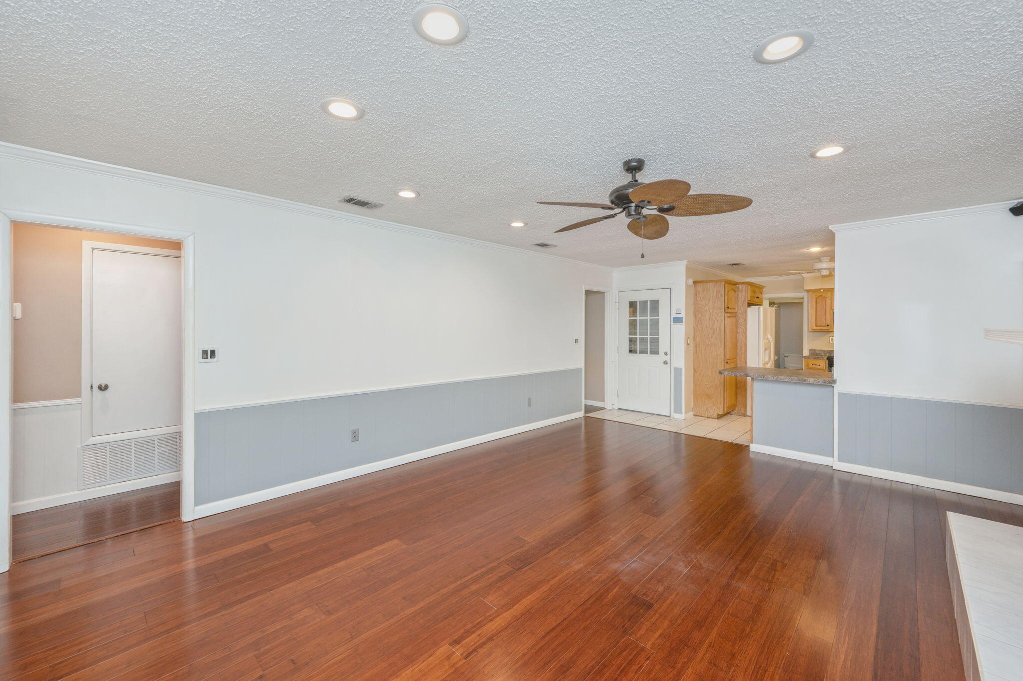 5770 Wildwood Road Crestview, FL 32536 - Photo 9 of 39 an empty room with wooden floor and a ceiling fan