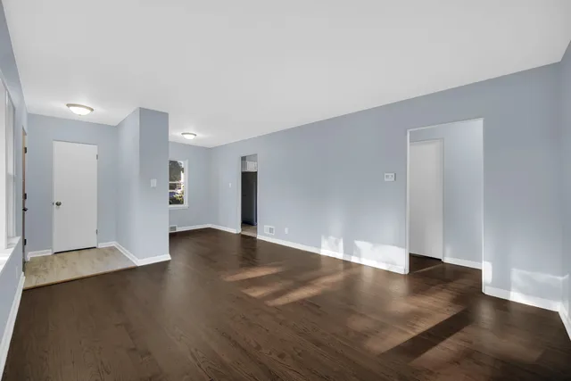a view of an empty room with wooden floor