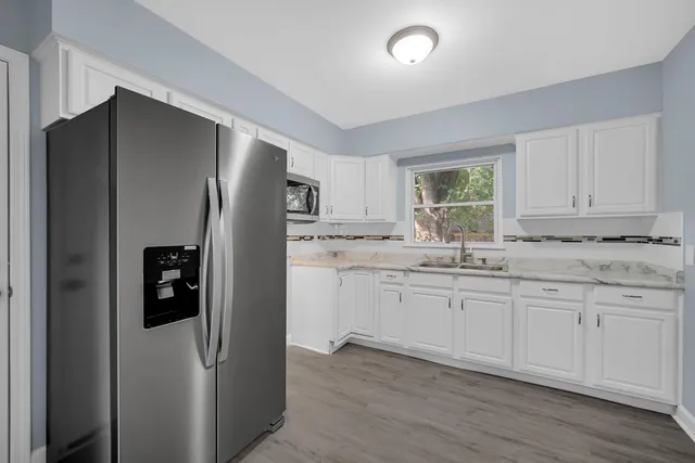 a kitchen with stainless steel appliances granite countertop a refrigerator and a sink