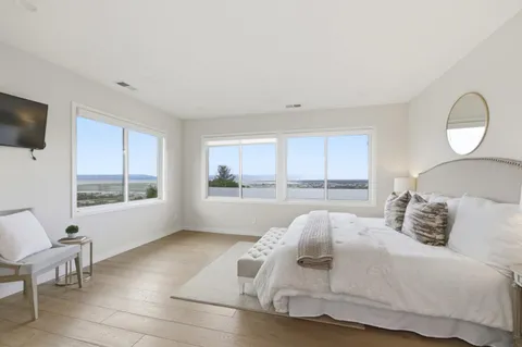 a spacious bedroom with a bed and glass window