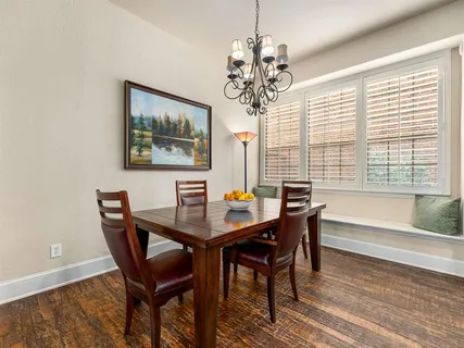 a view of a dining room with furniture a chandelier and wooden floor