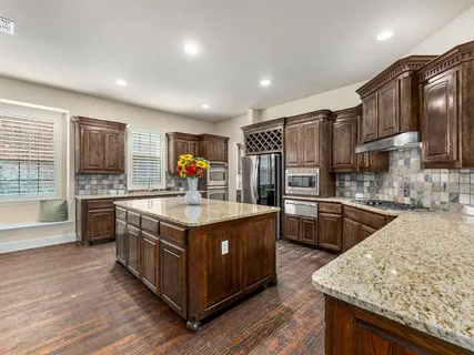 a kitchen with stainless steel appliances granite countertop a stove and a refrigerator