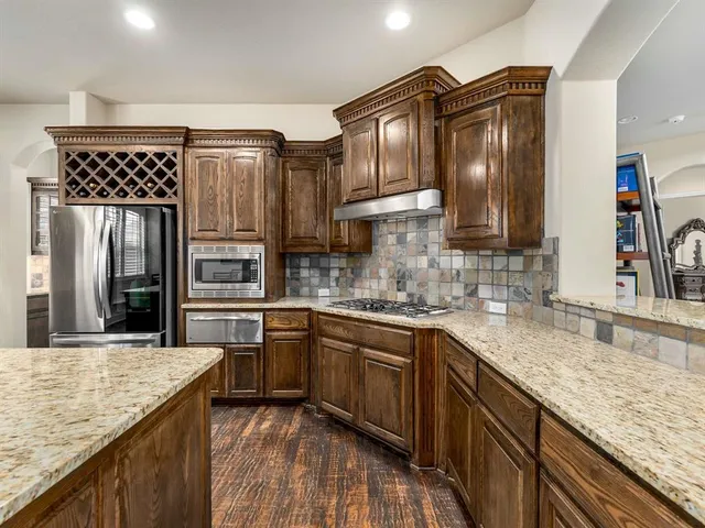 a kitchen with stainless steel appliances granite countertop a sink stove and refrigerator