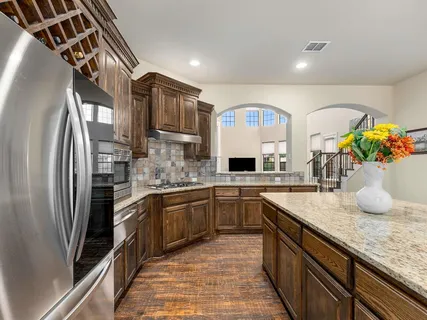 a kitchen with stainless steel appliances granite countertop a sink stove and refrigerator