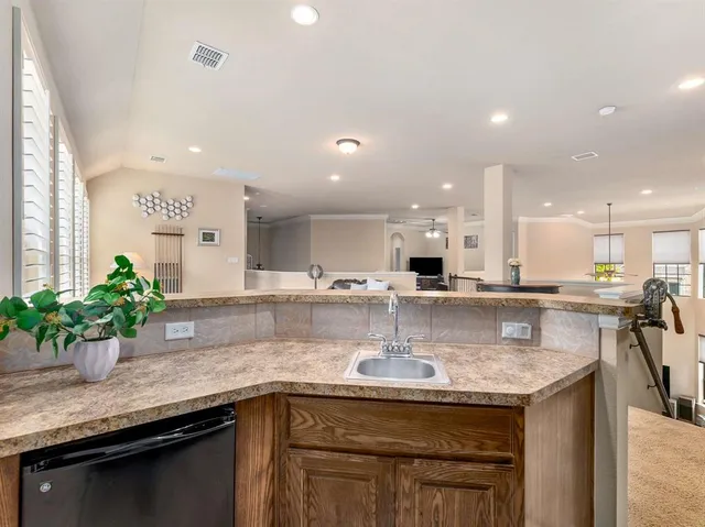 a kitchen with kitchen island granite countertop a sink a counter top stainless steel appliances and cabinets