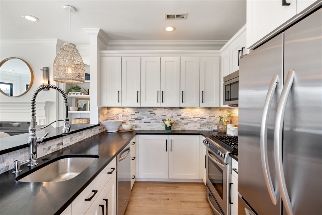 35 Rutherford Avenue, Unit 3 Boston, MA 02129 - Photo 7 of 28 a kitchen with granite countertop a sink stainless steel appliances and cabinets