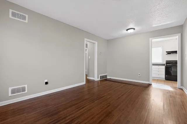 a view of an empty room with wooden floor