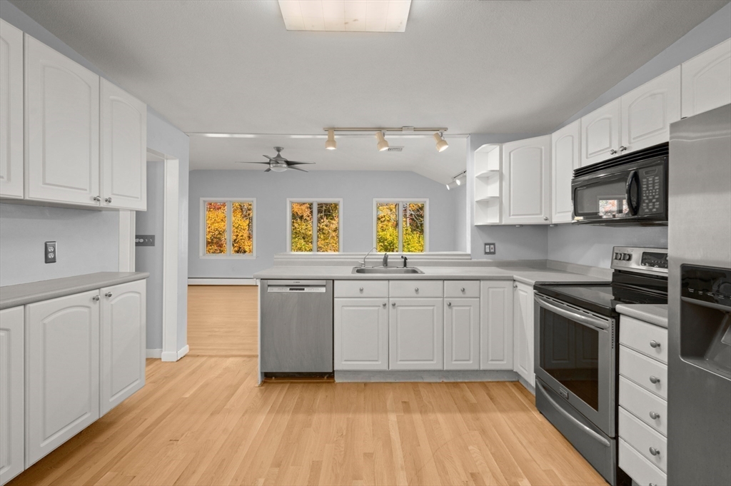 10 Strawberry Hill Road Andover, MA 01810 - Photo 12 of 41 a kitchen with a sink wooden floor and stainless steel appliances