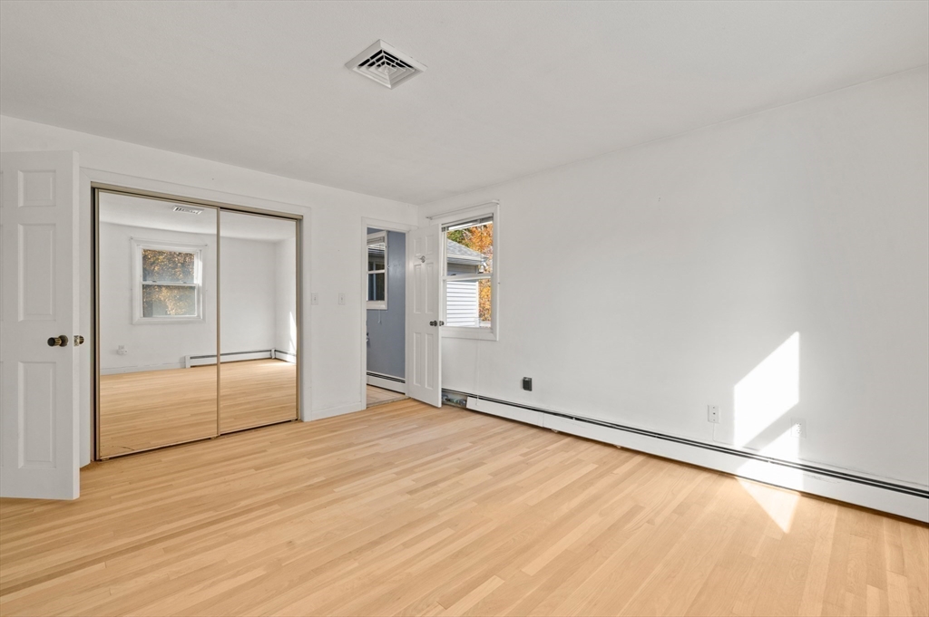 10 Strawberry Hill Road Andover, MA 01810 - Photo 20 of 41 a view of an empty room with wooden floor and a window