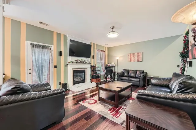 a living room with furniture a flat screen tv and a fireplace
