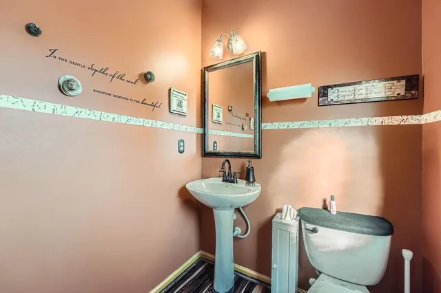 a bathroom with a sink mirror and toilet