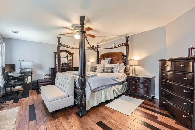 a bedroom with a bed and wooden floor