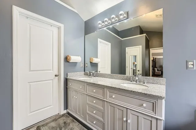 a bathroom with a double vanity sink and a mirror