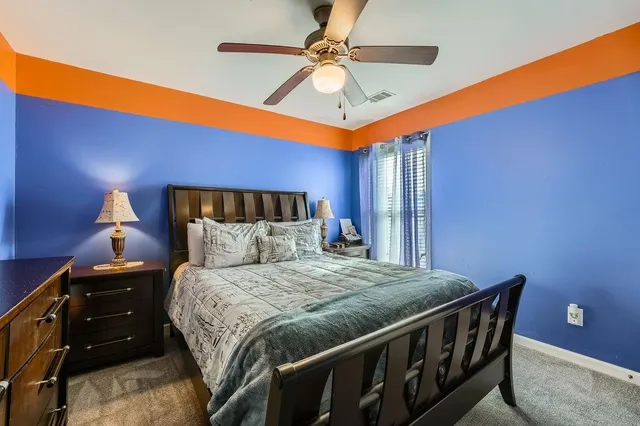 a bedroom with a bed and a ceiling fan
