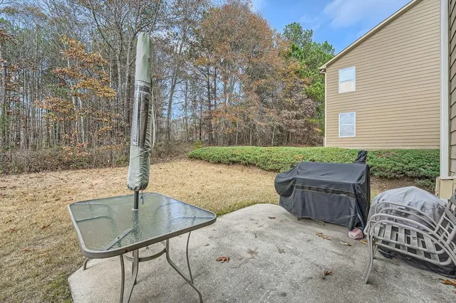 a backyard of a house with barbeque oven and outdoor seating