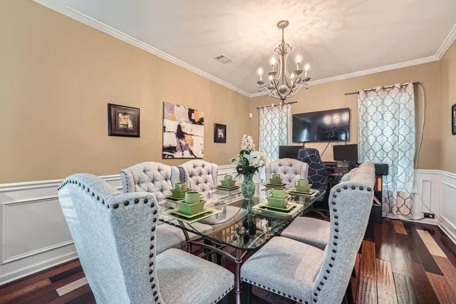 a view of a dining room with furniture a chandelier and wooden floor